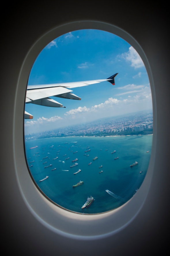 In-Flight view through an airplane window over Singapore. Photo by Amar Rai